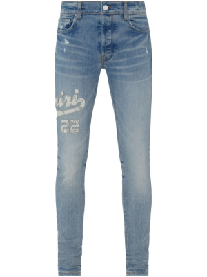 

Varsity logo appliqué skinny jeans, AMIRI Varsity logo appliqué skinny jeans