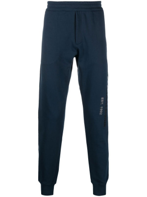 

Graffiti logo-print track pants, Alexander McQueen Graffiti logo-print track pants